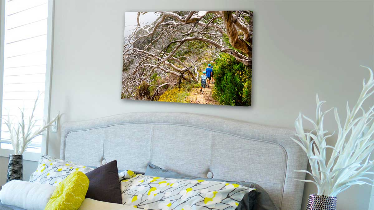 Canvas print on a bedroom wall featuring a photo of a family walk