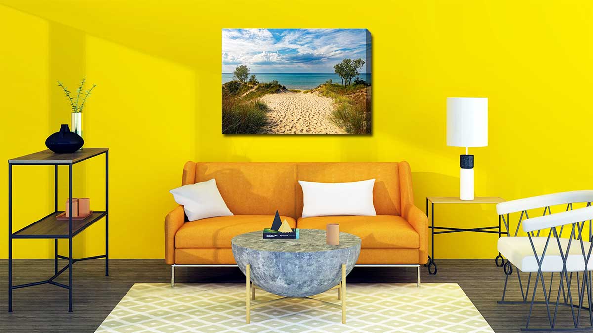 Landscape canvas of a beach hung on the wall of a sitting room