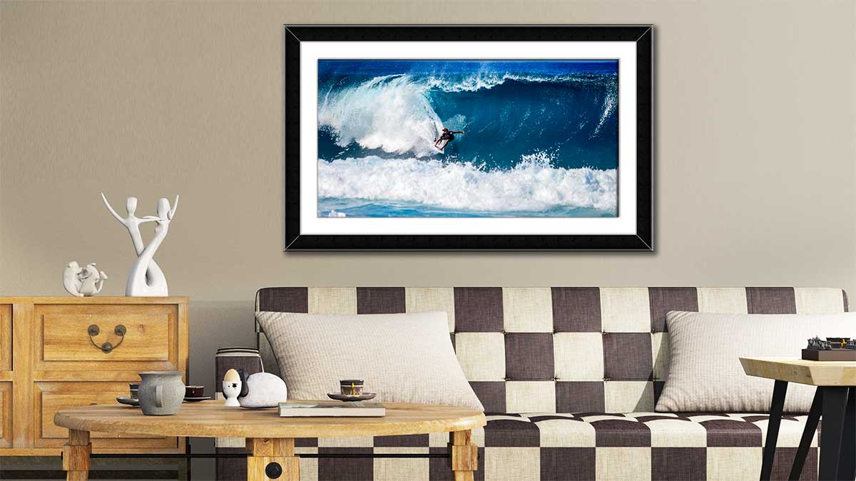 Framed picture featuring a surfer on a dramatic wave hung in an esoteric sitting room